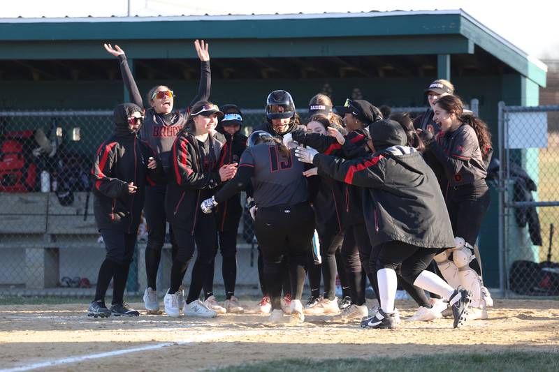 Bolingbrook’s Mackenzie McGrath is mobbed by her teammates after a solo run against Plainfield Central on Wednesday, March 20, 2024.