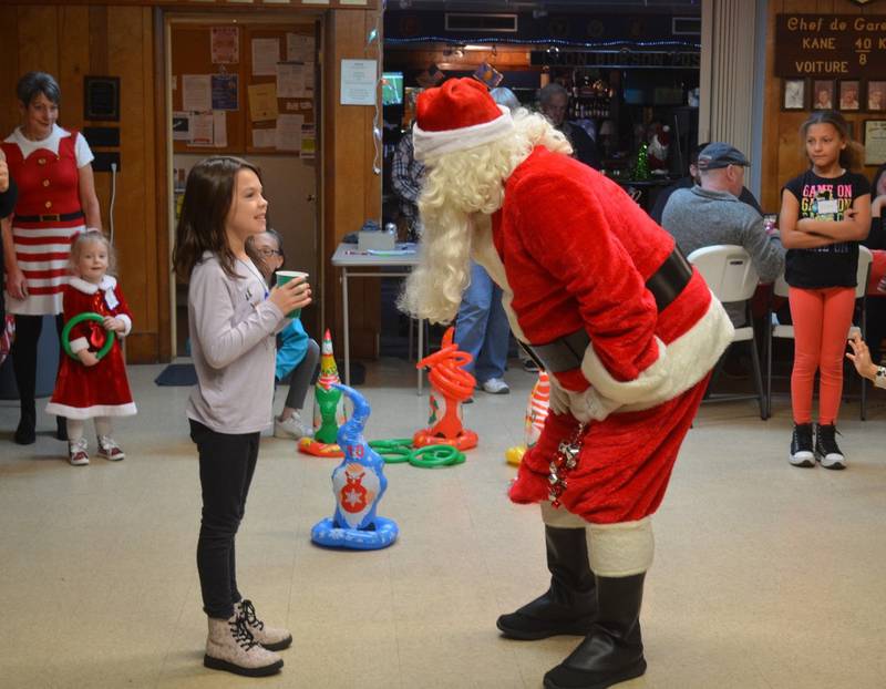 An attendee at the Plano American Legion Post #395 Children’s Christmas Party talks with Santa.