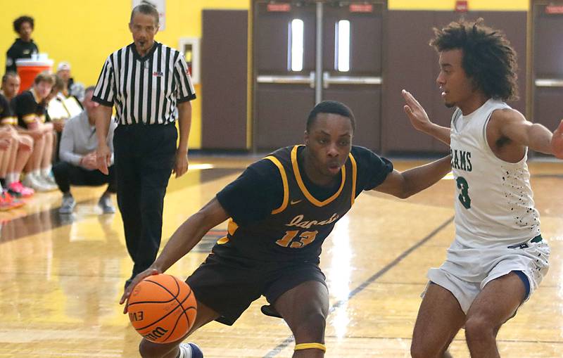 Jacobs’ Elijah Bell, left, moves the ball as Grayslake Central’s Alex Granville defends in varsity boys basketball Hinkle Holiday Classic action on Tuesday, Dec. 23, 2025, at Jacobs High School in Algonquin.