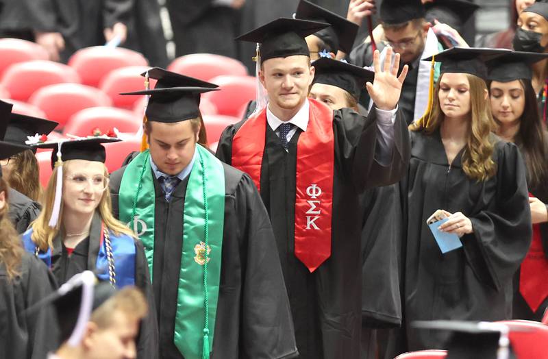 Candidates for graduation wave to friends and family as they head to their seats Saturday, May 14, 2022, during the first of two undergraduate commencement ceremonies at Northern Illinois University in DeKalb.