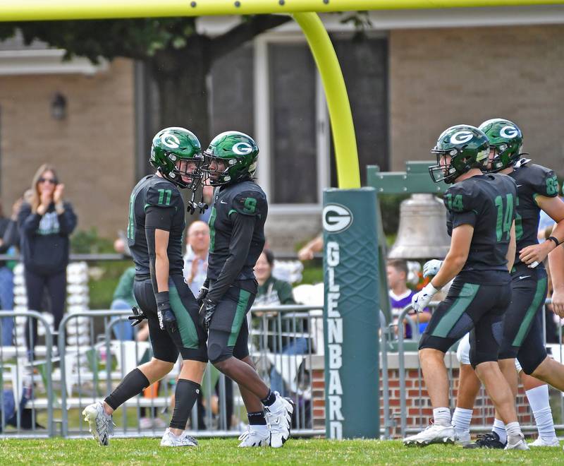 Glenbard West’s Chase Cavan and Jaylen McMiller (9) celebrate McMiller’s kick return for touchdown during a game against Joliet Catholic on September 6, 2025 at Glenbard West High School in Glen Ellyn.