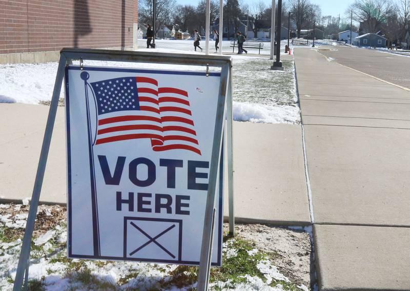 Students walk to school past a "Vote Here" sign on Tuesday, March 17, 2026 at Hall High School in Spring Valley.