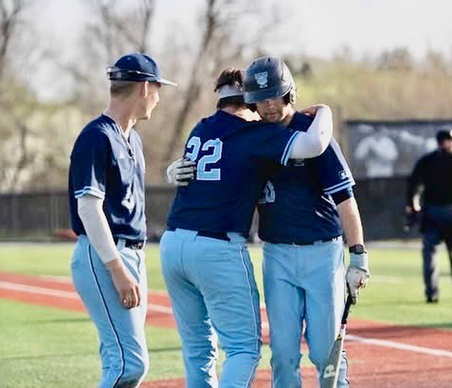 Princeton's Drew Woolley (right) gets a hug from teammates in his last game playing for Trinity Christian College in Palos Heights.