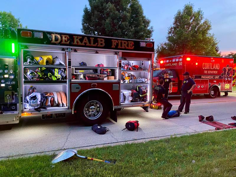 Firefighters gather around gear strewn on the ground in the 600 block of Ridge Drive on Sunday, July 27, 2025, as crews undertake an emergency water rescue at a nearby pond.