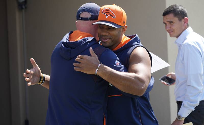 Denver Broncos head coach Nathaniel Hackett, left, hugs quarterback Russell Wilson as he heads to a news conference before the NFL football team's practice Thursday, Sept. 8, 2022, at the Broncos' headquarters in Centennial, Colo. The Broncos open the NFL season Monday night against the Seahawks in Seattle. (AP Photo/David Zalubowski)
