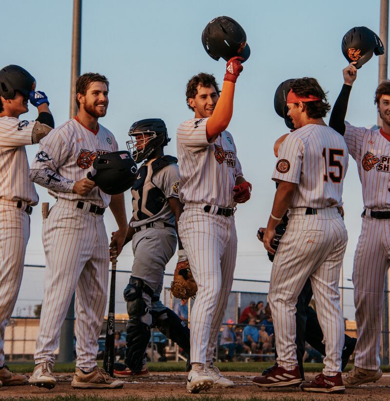 Ryan Niedzwiedz (center) celebrates with teammates after hitting a three-run home run during the Illinois Valley Pistol Shrimp's 11-0, seven-inning victory over the Burlington Bees on Friday, July 19, 2024 at Schweickert Stadium in Peru.