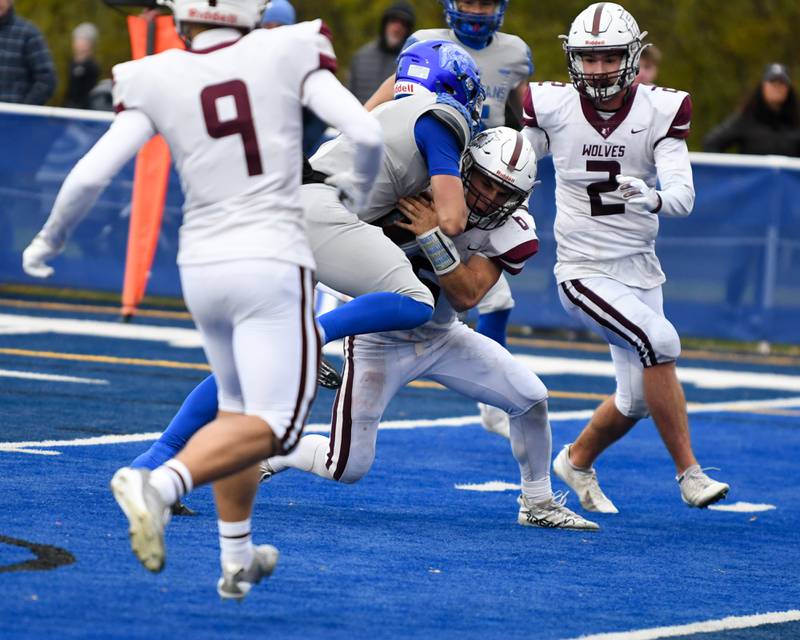 St. Francis's Brock Phillip, center, gets into the endzone while being defended by Prairie Ridge's Luke Vanderwiel (6) during the second round of the 5A playoff game on Saturday Nov. 8, 2025, held at St. Francis's High School.