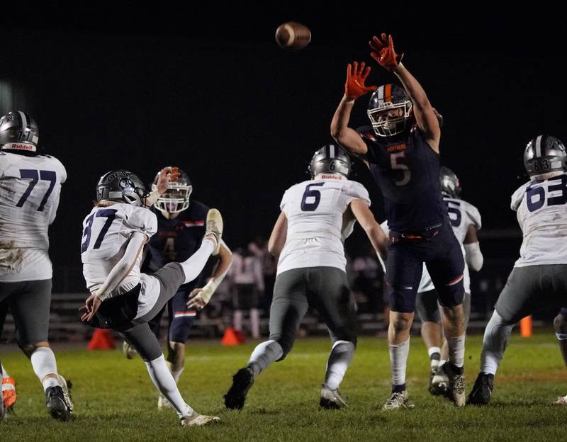 Oswego East's Caden Bregar (37) punts the ball over Oswego’s Carson Cooney (5) during a football game at Oswego High School on Friday, Oct. 20, 2023.