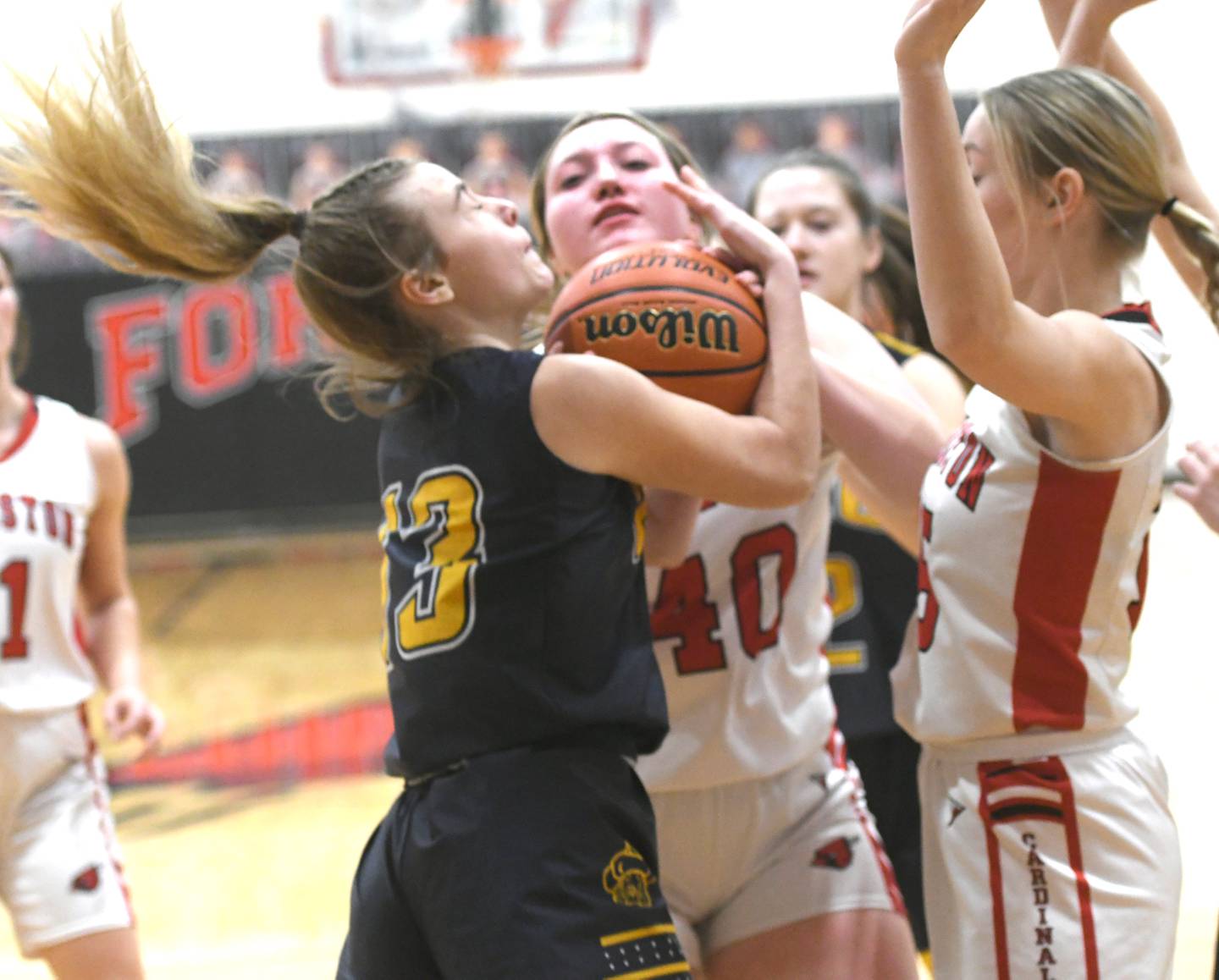 Polo's Madison Glawe (13) wraps up the ball as she battles Forreston's Keeli Larson and Autum Pritchard for a rebound during Jan. 6 action in Forreston.