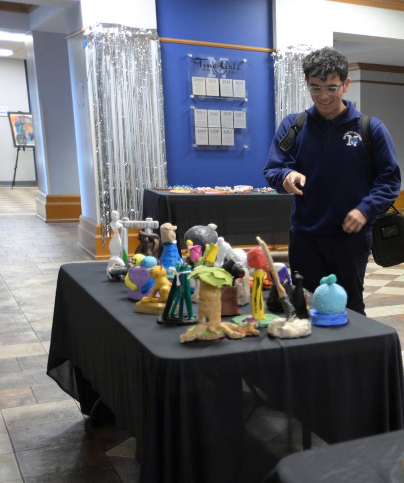 Nazareth students including Junior, Paublo Guerrero look at the art work created by all the art classes during the Expressive Arts Showcase held Monday, April 8, 2024.