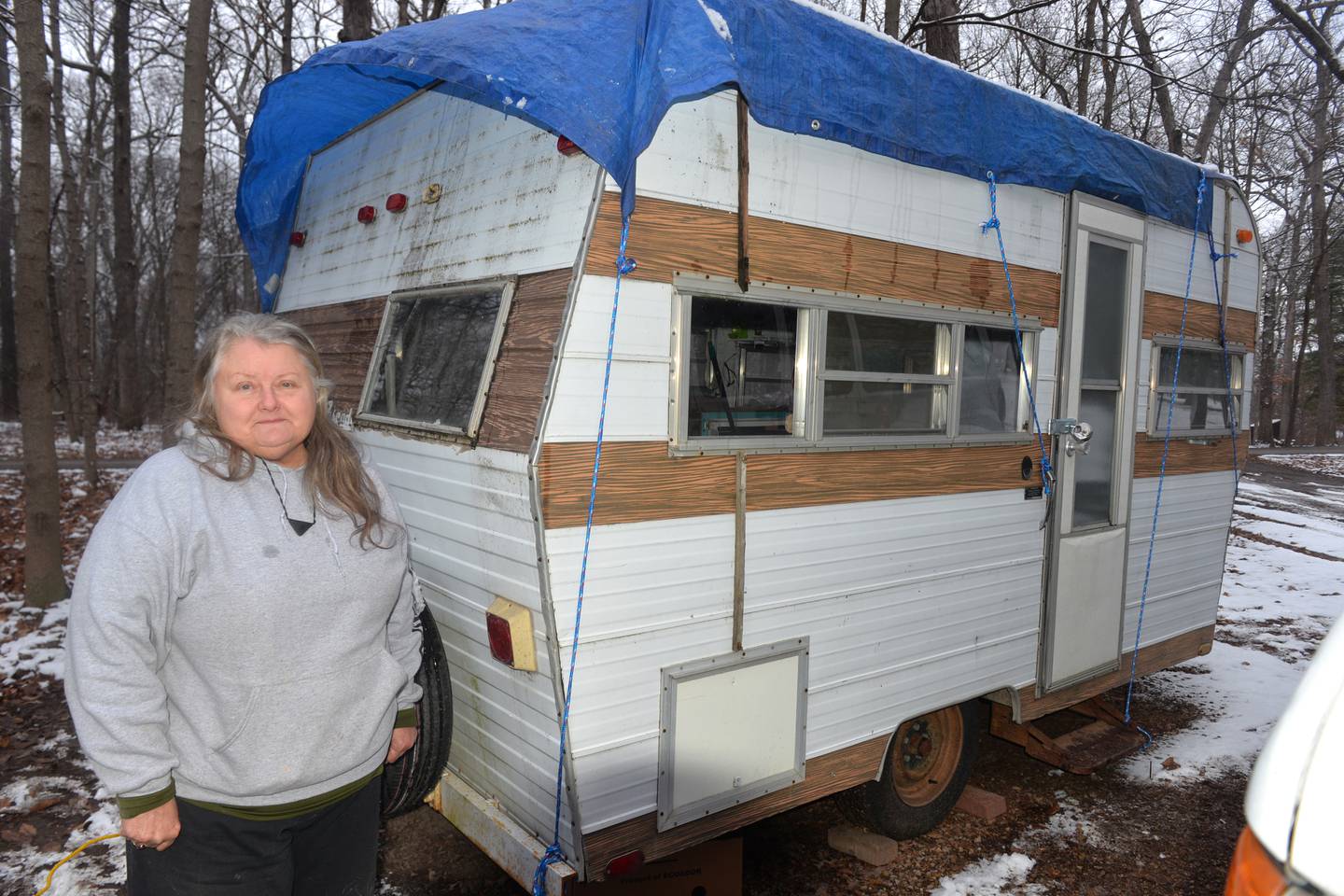 Sarah Wright stands by the 1975 camping trailer on Sunday, Jan. 7, 2024. The 8' x 15' camper was given to her by Brad Parkinson of Oregon. Wright plans on using the camper this winter after some repairs are made.