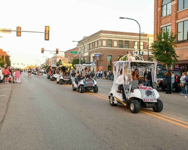 Sycamore High School Homecoming candidates drive golf carts on Wednesday, Oct. 8, 2025, during the Homecoming parade downtown.