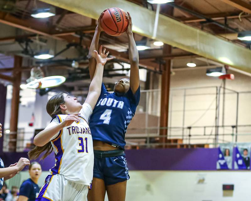 Downers Grove South's Hayven Harden (4) battles Downers Grove North's Ann Stephens (31) for a rebound during girls basketball game between Downers Grove South at Downers Grove North. Dec 16, 2023.