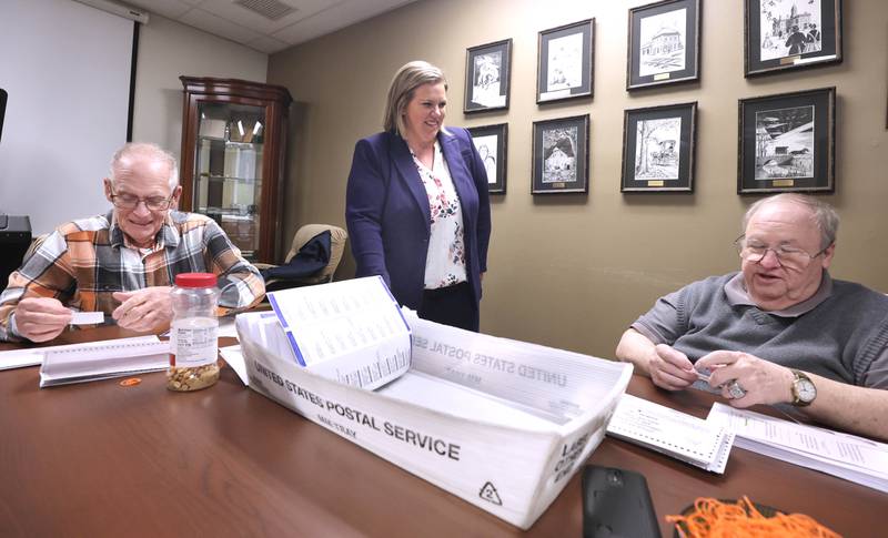DeKalb County Clerk Tasha Sims visits with election judges Terry Heiland (left) and Steve Nemeth as they put vote-by-mail ballots in envelopes Wednesday, Feb. 22, 2023, in the DeKalb County Administration Building in Sycamore.