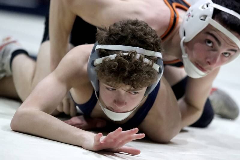 Crystal Lake Central’s Jackson Marlette, top, battles Cary-Grove’s Gunner Cotte at 113 pounds in varsity wrestling Thursday, Dec. 19, 2024 at Cary-Grove High School in Cary.