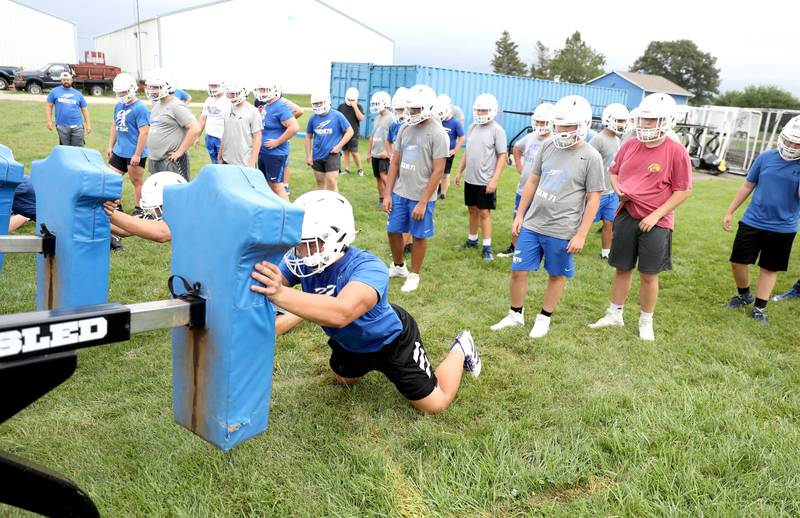Burlington Central’s James Muetterties hits the sled during the first official practice of the season on Monday, Aug. 8, 2022.