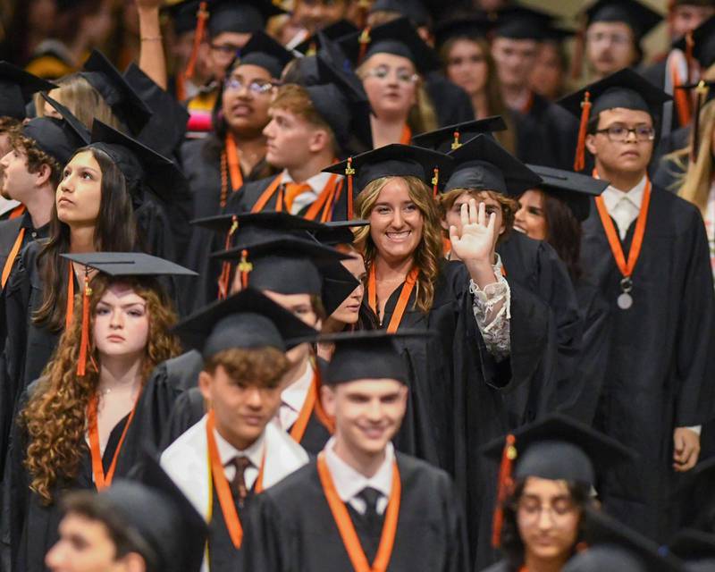 A St. Charles East graduate waves as she enters the commencement ceremony on Monday, May 18, 2026, held at the Convocation Center in DeKalb.