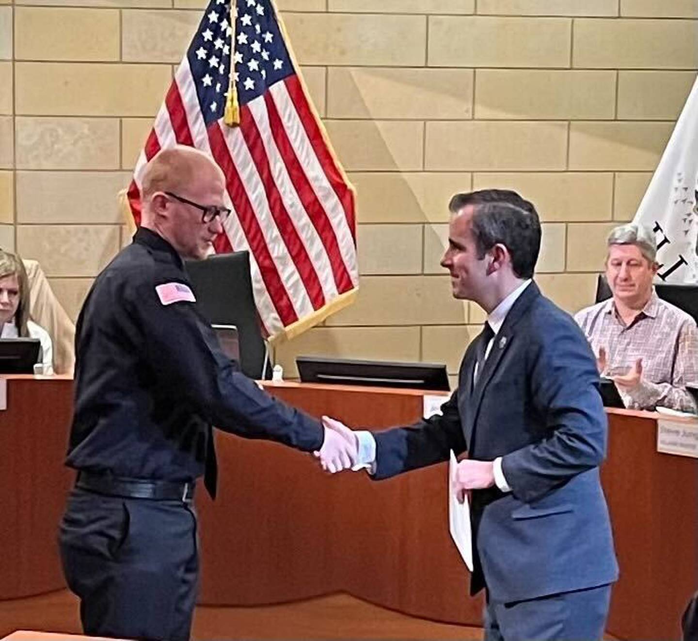 Montgomery Village President Matt Brolley congratulates Caine Culver, left, on his swearing-in as a village police officer during a Village Board meeting Monday, Jan. 23, 2023. At far right is Jeff Zoephel, village administrator.