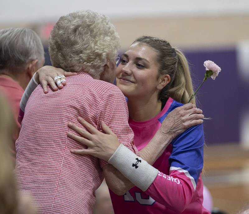 Dixon’s Solis Thompson gives a carnation to Louise Reed Thursday, Oct. 2, 2025, to honor those who have fought cancer during Pink Out night at DHS.