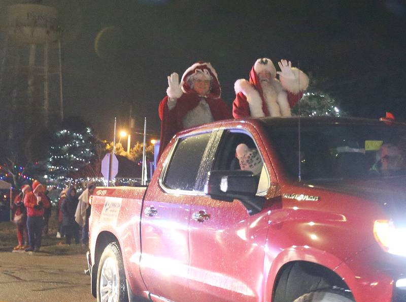 Miss Claus and Santa wave to spectators as they ride in the inaugural Lighted Christmas Parade on Friday, Dec. 1, 2023 in Princeton.