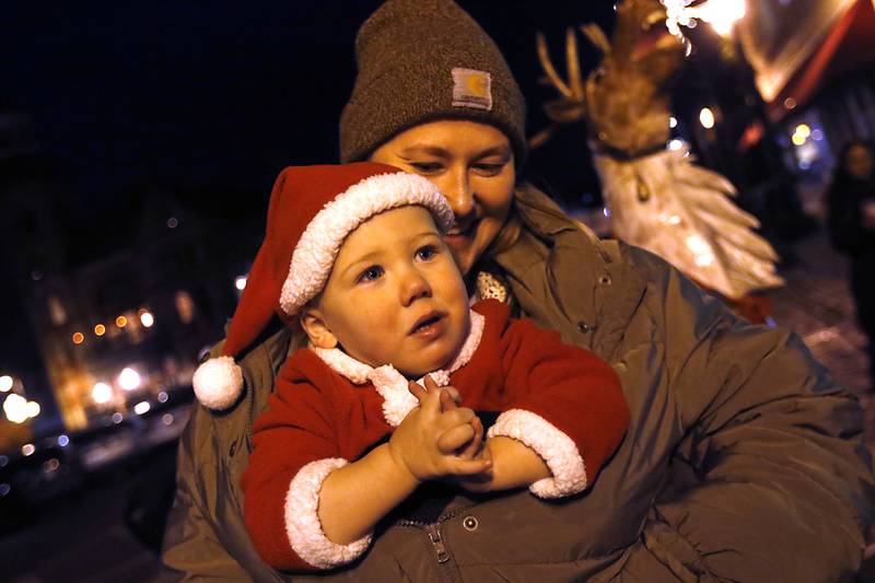 Henry Gottardo keeps warm inside his mom’s coat during the Lighting of the Square Friday, Nov. 29, 2024, in Woodstock. The annual holiday season event featured brass music, caroling, free doughnuts and cider, food trucks, festive selfie stations and shopping.