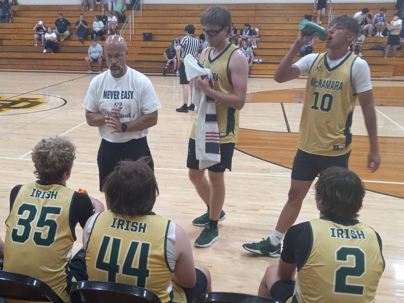 Bishop McNamara head coach Adrian Provost, left, addresses his team between quarters of a game at the Braidwood Shootout on June 12, 2025.