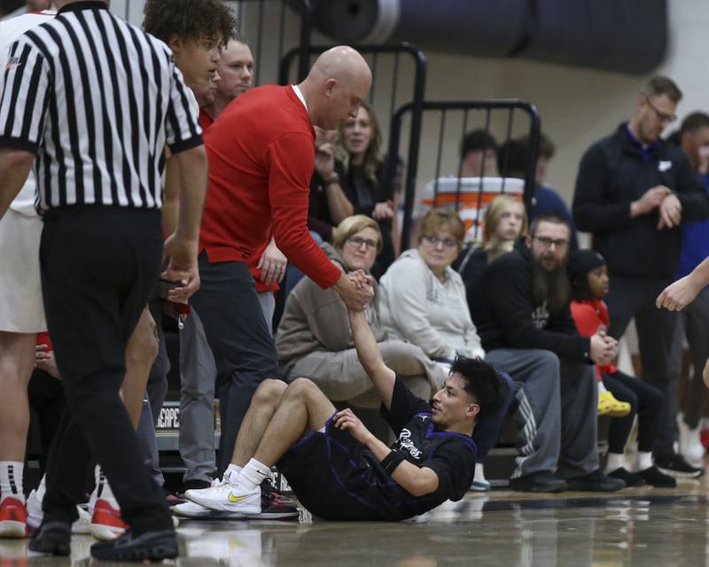 Streator's head coach Beau Doty helps up Plano's Alan Contreras (1) after he was called on a blocking foul during their Plano Christmas Classic basketball game between Streator at Plano Friday, Dec 26, 2025 in Plano.