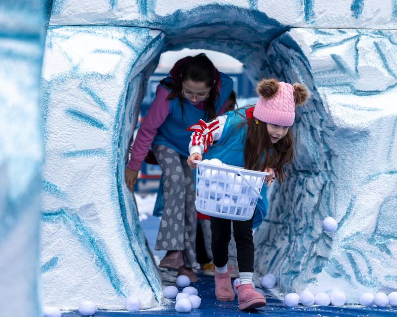 Kids walk out of "glacier" tunnel at the annual 'Ax Church Ultimate Snowball Fight' at Frosty on First on Saturday, November 8, 2025 on First Street in La Salle.