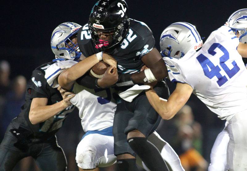 Woodstock North’s David Randecker, center, is met by Woodstock’s Andrew Ryan, left, and Zachary Canaday, right, in varsity football at Woodstock North Friday night.