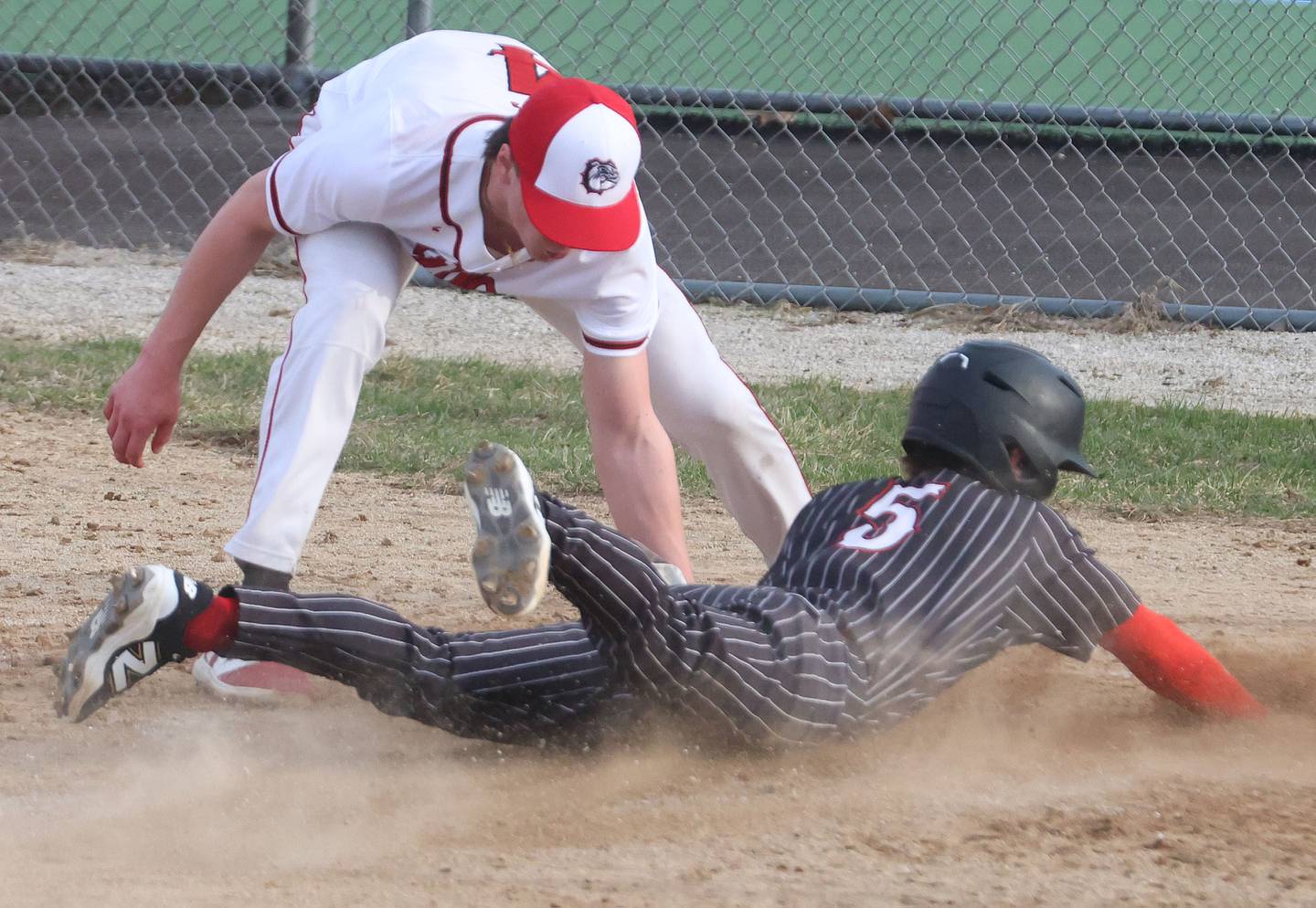 Streator's Clay Christoff tags out Hall's Greyson Bickett while sliding into home on Thursday, March 19, 2026, at Streator High School.