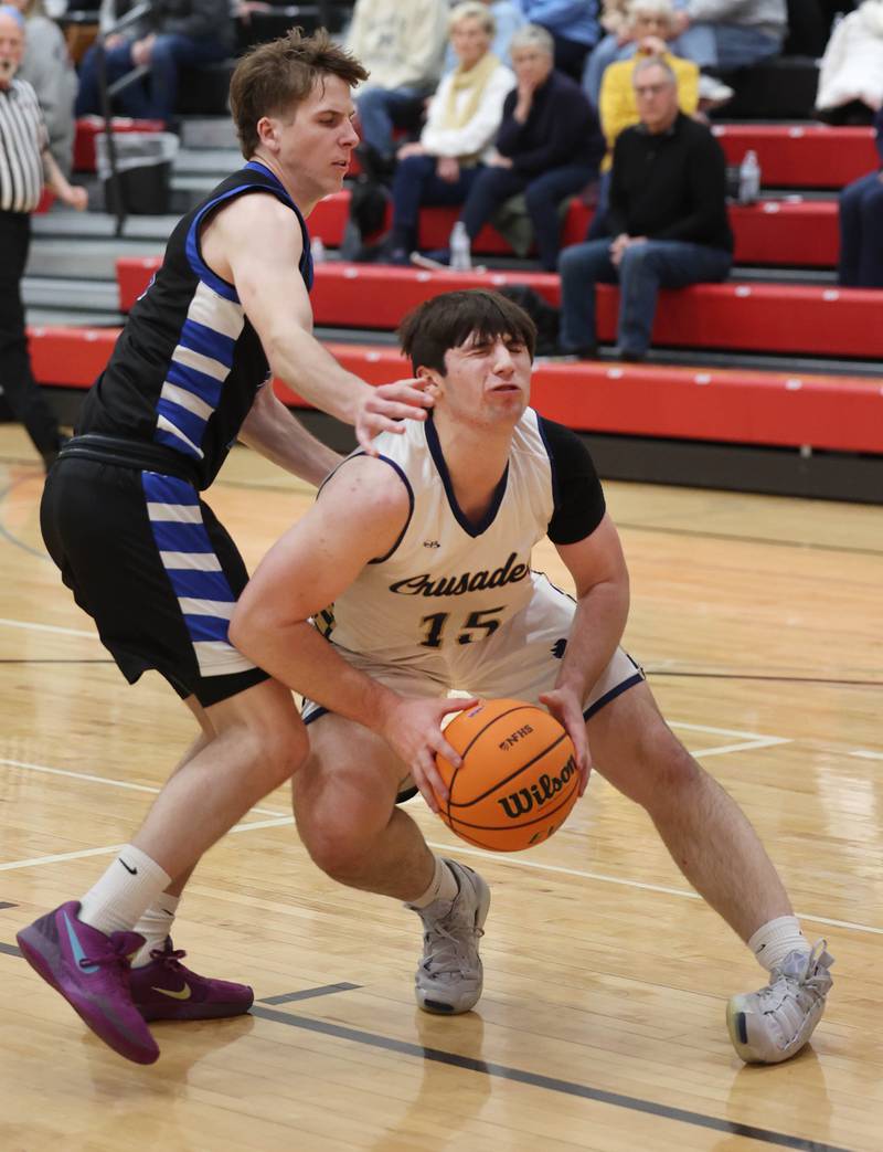 Marquette's Alec Novotney rolls his ankle as he tries to shoot over Hinckley-Big Rock's Harrison Nier Tuesday, March 3, 2026, during their sectional semifinal matchup at Amboy High School.