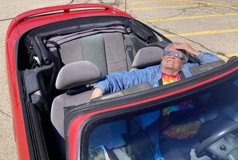 Steven Franzen of McHenry watches the partial eclipse Monday, April 8, 2024,from his convertible at the Crystal Lake Park District's Nature Center.
