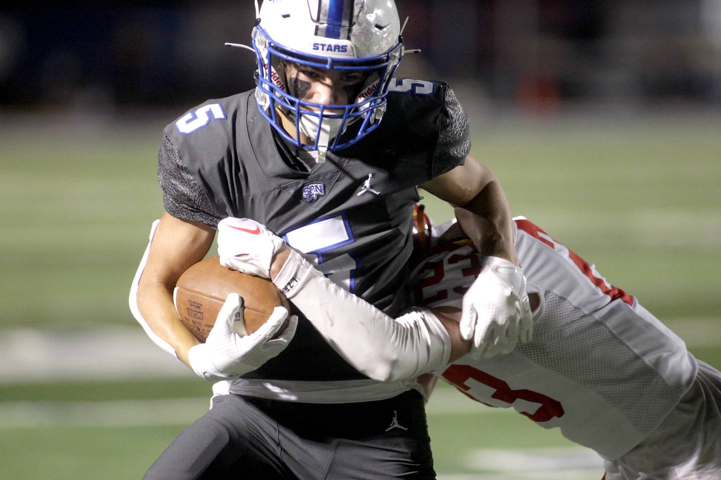 St. Charles North’s Anthony Taormina carries the ball as he fights off Batavia’s Josh Kahley during a game at St. Charles North on Friday, Sept. 15, 2023.