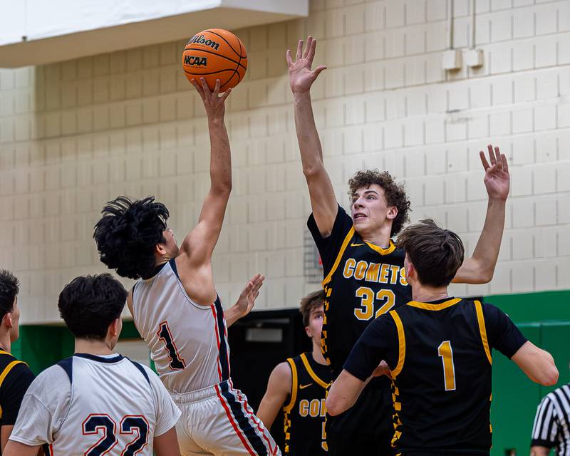 Pedro Lopez (1) of DePue lays ball up as Vinny Bollino (32) of Reed-Custer jumps in attempt to block shot in the Shipyard Showdown on Tuesday, December 23, 2025 at Seneca High School in Seneca.