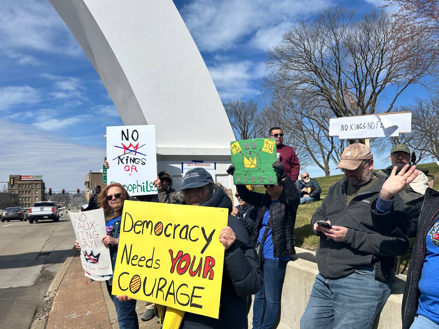 A group of protestors holds up signs while under the Dixon Arch on Saturday afternoon outside of the Old Lee County Courthouse.
