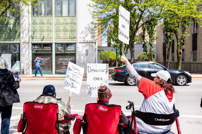 Attendees hold up a signs at the May Day Weekend Rally in Downtown Joliet on May 3, 2025.