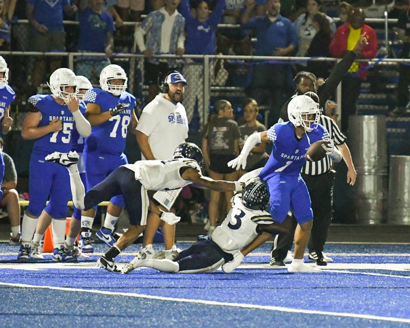 St. Francis Corin Greenwell, right, is brought down by IC Catholic Prep Kaleb Ellis (3) and KJ Parker, left, after Corin picks off and interception during the second quarter on Friday Sep. 29, 2023, held at St. Francis in Wheaton.