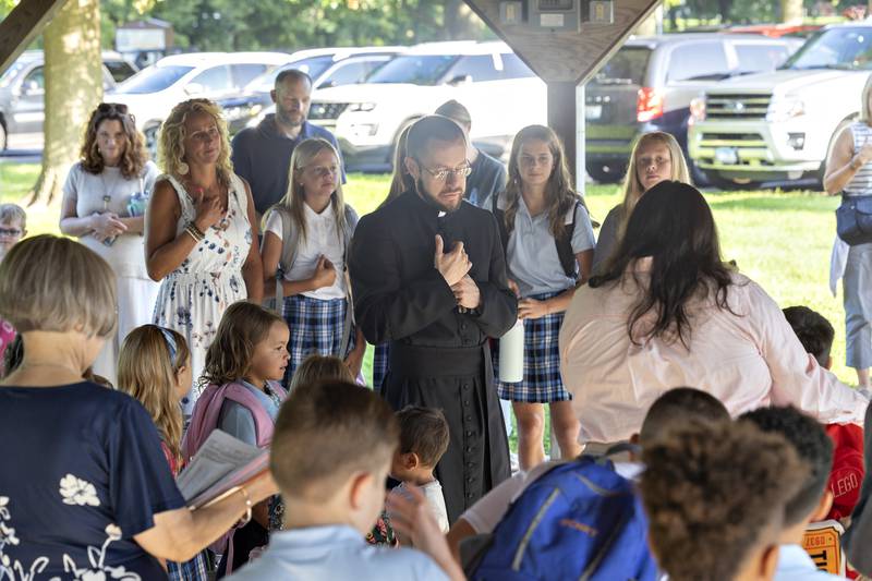 Father Tim Draper leads a group in prayer Wednesday, Aug. 13, 2025, as St. Anne’s students return to class for the 2025-26 school year.