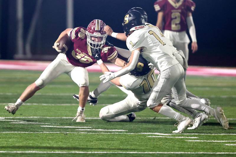 Morris’ Jacob Swartz is pulled down by Sycamore's Burke Gautcher and Colton Sharpness during their game Friday, Oct. 20, 2023, at Morris High School.