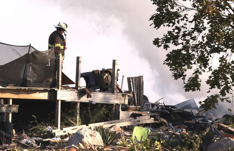 A firefighter overlooks the smoldering rubble that was a house Tuesday, Oct. 17, 2023, after an explosion at the residence on Goble Road in Earlville. Several fire departments responded to the incident at the single-family home that left one person hospitalized.