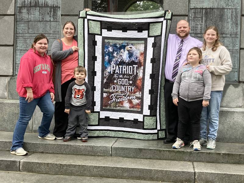 Mitch McCoy a retired U.S. Army and a father of four from Princeton, received the Quilt of Valor during Monday's 9-11 Remembrance Ceremony at Soldiers and Sailors Park. He is pictured with his wife, Katie, and their children (from left) Makaylee, Maxton, Mairyn and Myla.