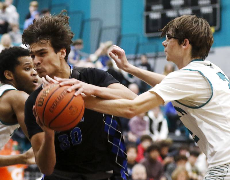 Woodstock's Spencer Cullum is fouled by Woodstock North's Logan Schwoch as Cullum drives to the basket during a Kishwaukee River Conference boys basketball game on Friday, Jan. 5. 2024, at Woodstock North High School.