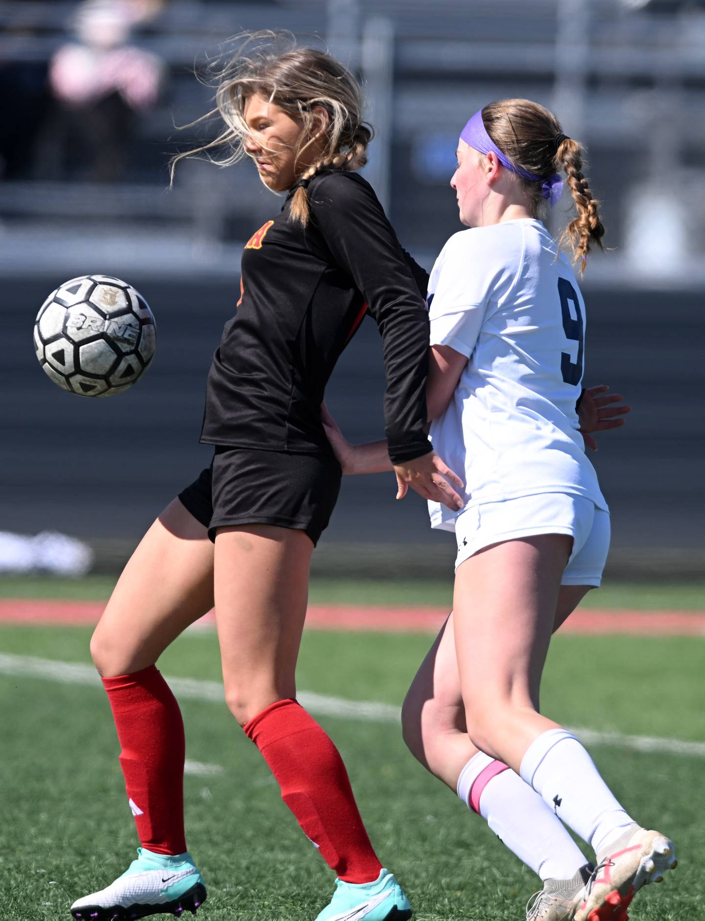 Batavia’s Natalie Warner, left, gets between the ball and  Oswego East’s Emma Klosterman during a girls soccer match on Saturday, March 23, 2024 in Batavia.
