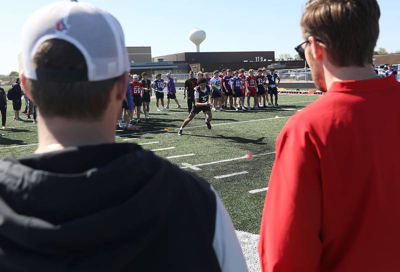 Carthage College coaches watch as Huntley's Malik Carter runs an agility drill at the Northern Burbs Football Showcase on Monday, May 4, 2026, at Johnsburg High School. Over 165 players from 15 teams demonstrated their football skills to over 60 college coaches.