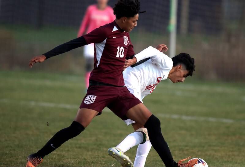 Dundee-Crown’s  Miguel Pena, right, staves off Elgin’s Miguel Navarro in Class 3A boys soccer sectional semifinal action at Hampshire on Wednesday.