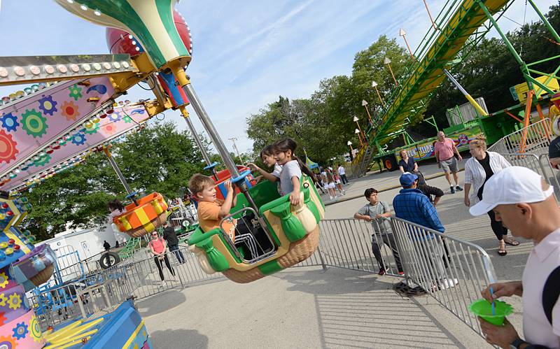 Children including Sammy Pritchett of Elmhurst and (left) Jojo and Alex Lee of LeGrange Highlands enjoy the balloon ride at the LaGrange Endless SummerFest Sunday Aug 6, 2023.