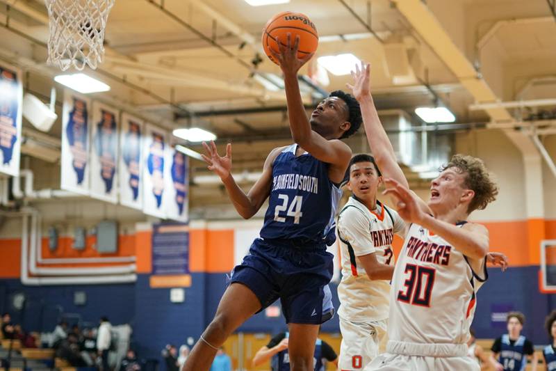 Plainfield South's Brandon Pearce (24) drives to the basket against Oswego’s Ethan Vahl (3) and Brayden Borrowman (30) during a basketball game at Oswego High School on Friday, January 17, 2025.