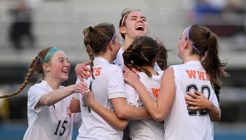 Wheaton Warrenville South players Eleanor Whaley (15), Ashley Alman (4) Ella Byrnes (facing) and Berkley Dylla (22) mob teammate Lily Petrie after she scored a first-half goal during Thursday’s girls soccer match at Wheaton North.