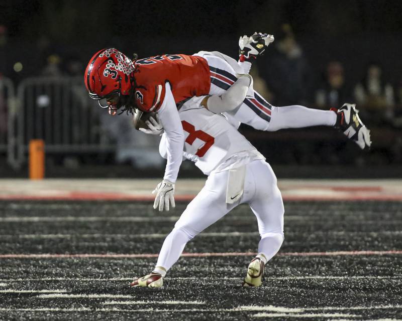 Bolingbrook's Jeremiah Jenkins (3) is up ended by Yorkville's Luke Hendershott (3) during football game between Yorkville at Bolingbrook Friday, Oct 24, 2025 in Bolingbrook.