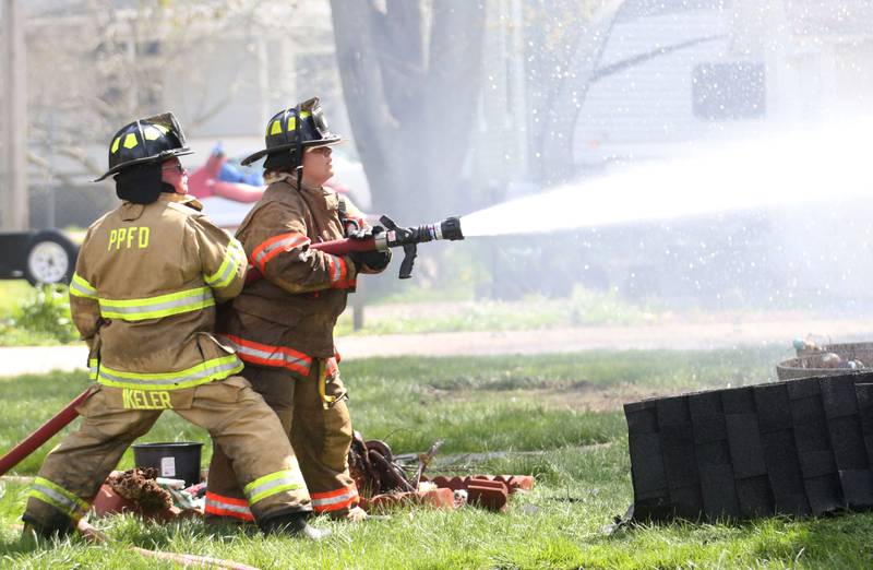 Paw Paw firefighters spray water on a home in 300 block of Maple Street on Monday, April 22, 2024 in Earlville. The fire happened around 10a.m.